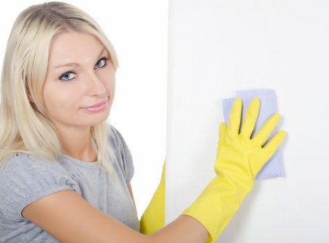 Cleaner wearing PPE while carrying out a detailed cleaning task